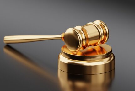 Golden gavel on reflective background
