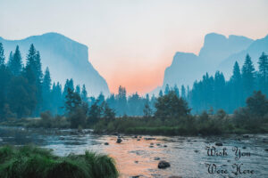 landscape scene showing river leading to tree covered mountains in the background. on the bottom right the text Wish You Were Here appears