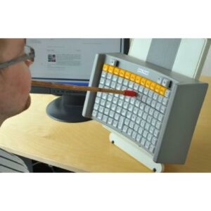Image shows man with mouth stick which he is using to type into a keyboard