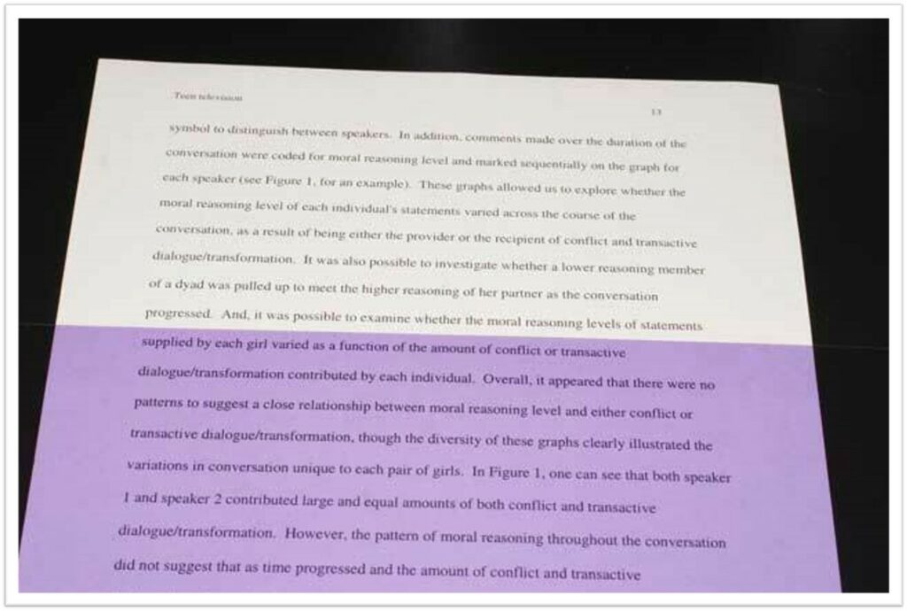 Image shows a document of black text on white paper with a prple overlay over the lower half of it.