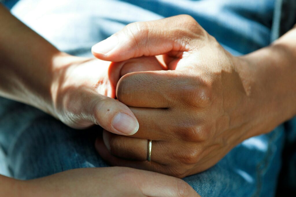 Two people holding hands depicting a caring relationship