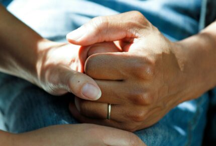 Two people holding hands depicting a caring relationship