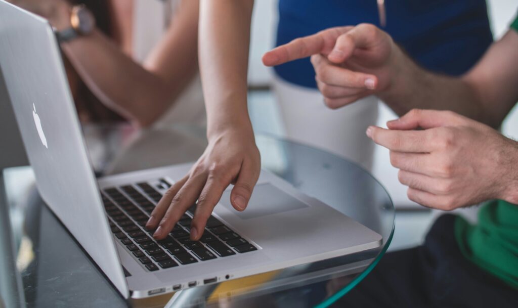 Hands pointing at a laptop