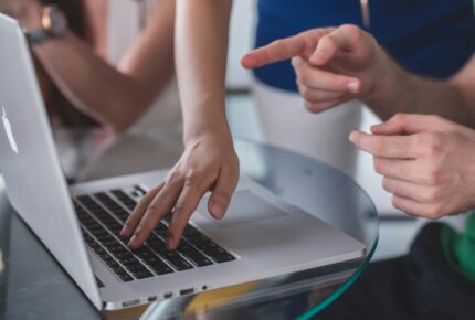 Hands pointing at a laptop